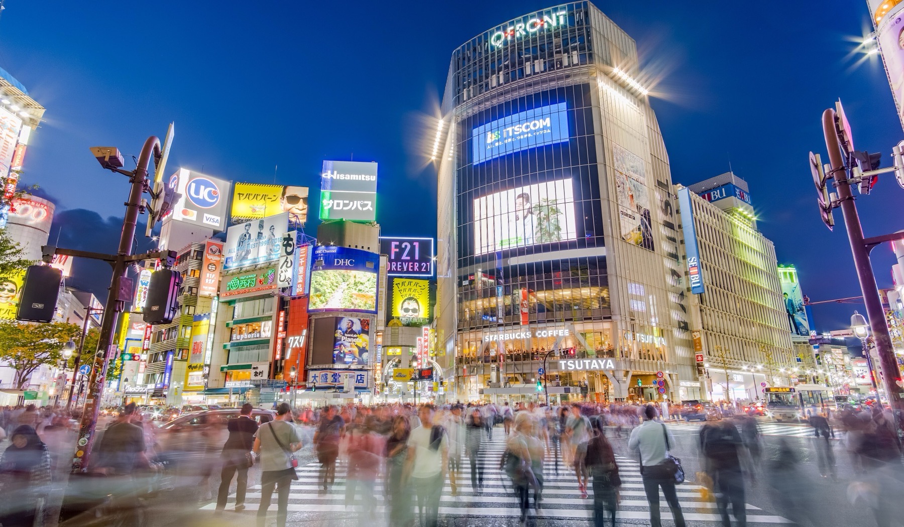 Pedestrians crossing Shibuya Scramble in Tokyo at dusk