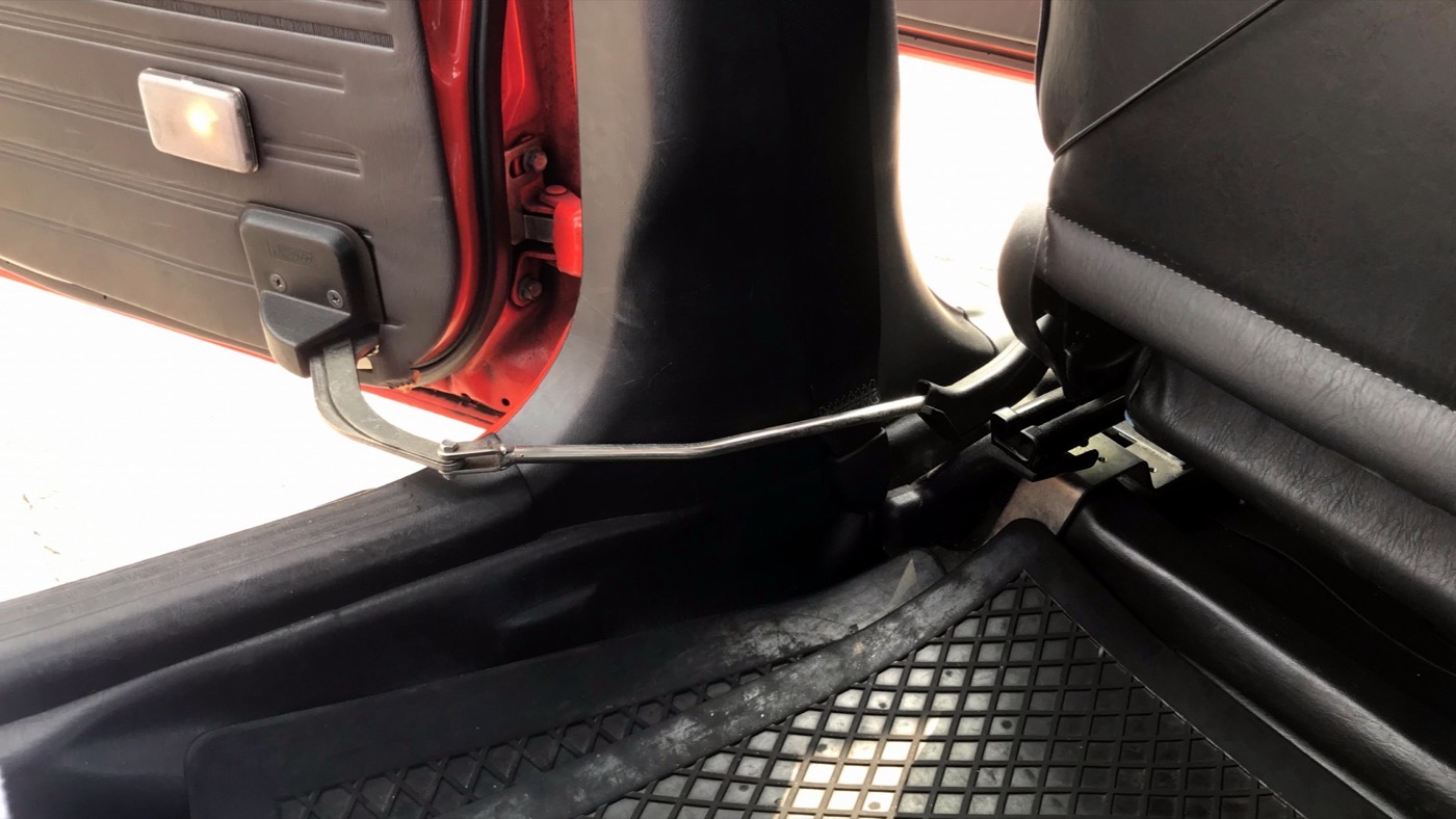 運転席から後部扉を開く、タクシーの機械式のロッド