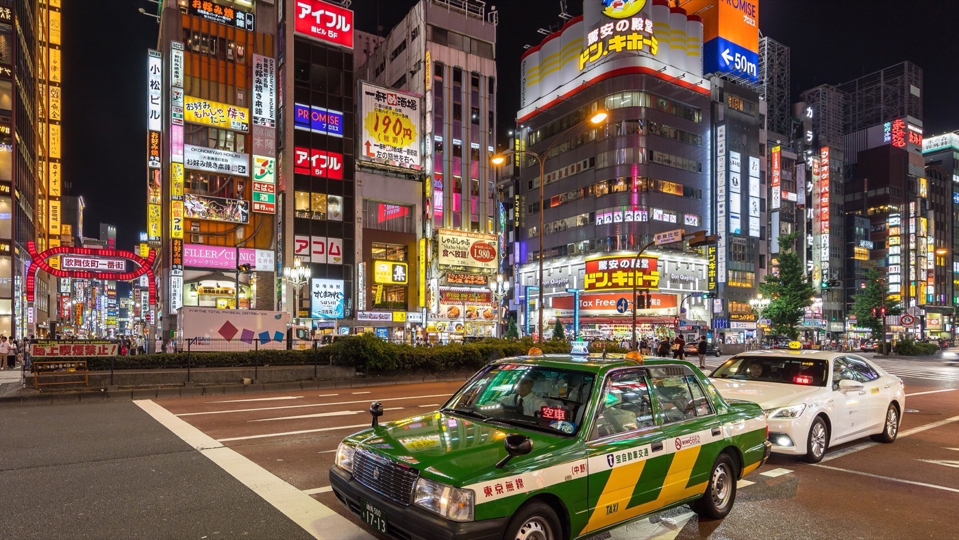 夜の東京・新宿の靖国通りで客待ちをするタクシー